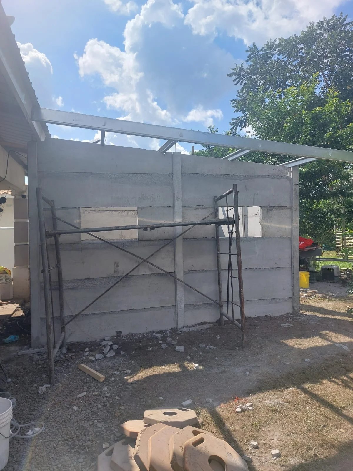 Cuarto de servicio prefabricado con muros de concreto y techo metálico en proceso de obra
